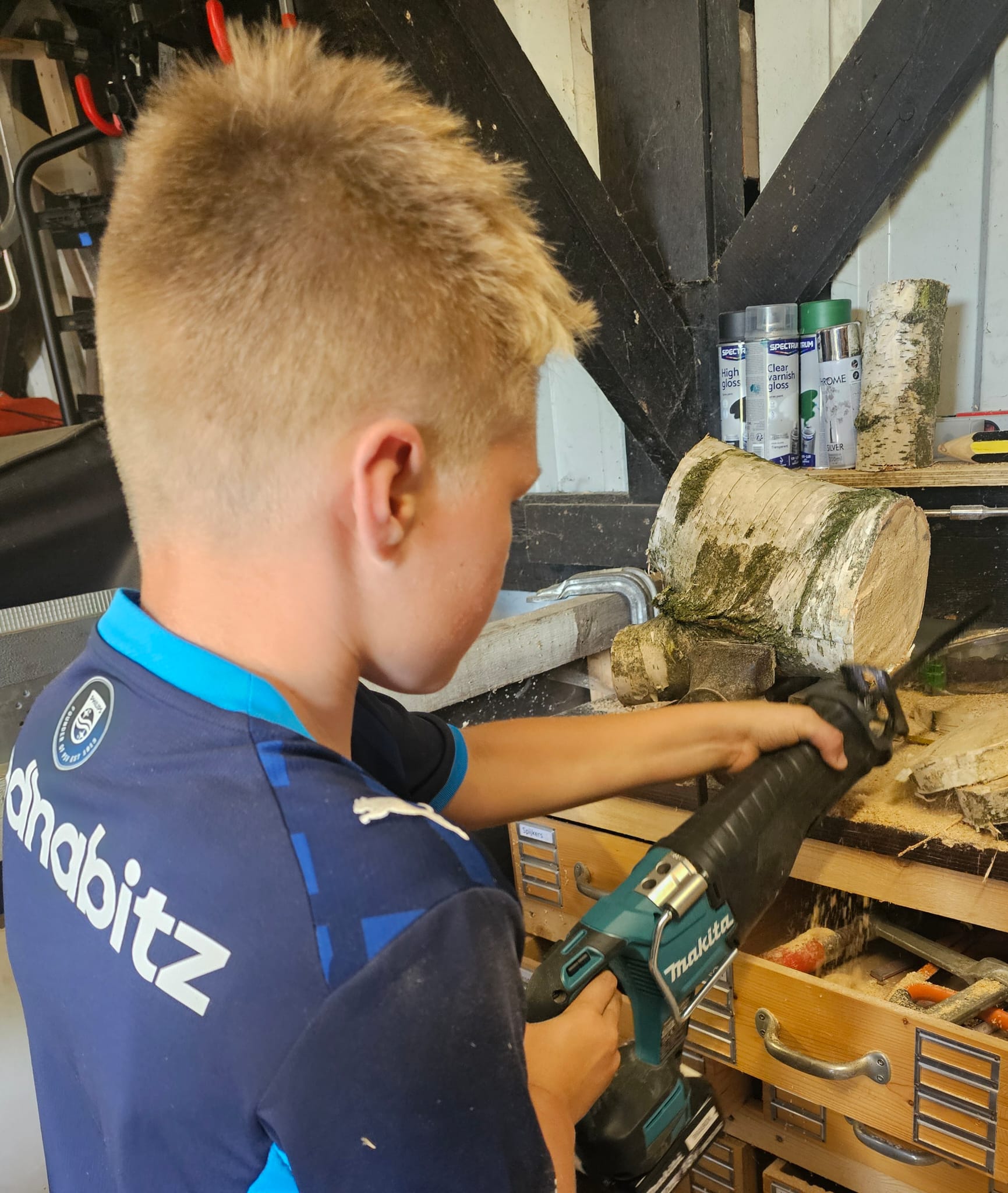 Tim aan het werk met hout in de schuur